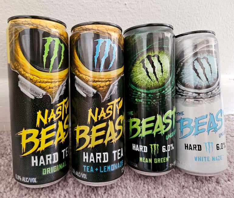 the beast can lineup by Monster Brewing on carpet against wall