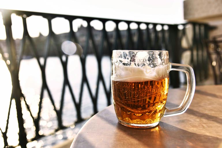 beer mugs with beer quote on table outside with river