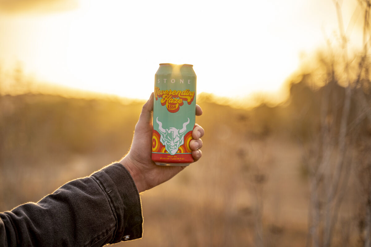 stone brewing co. neverending haze ipa in front of sunset