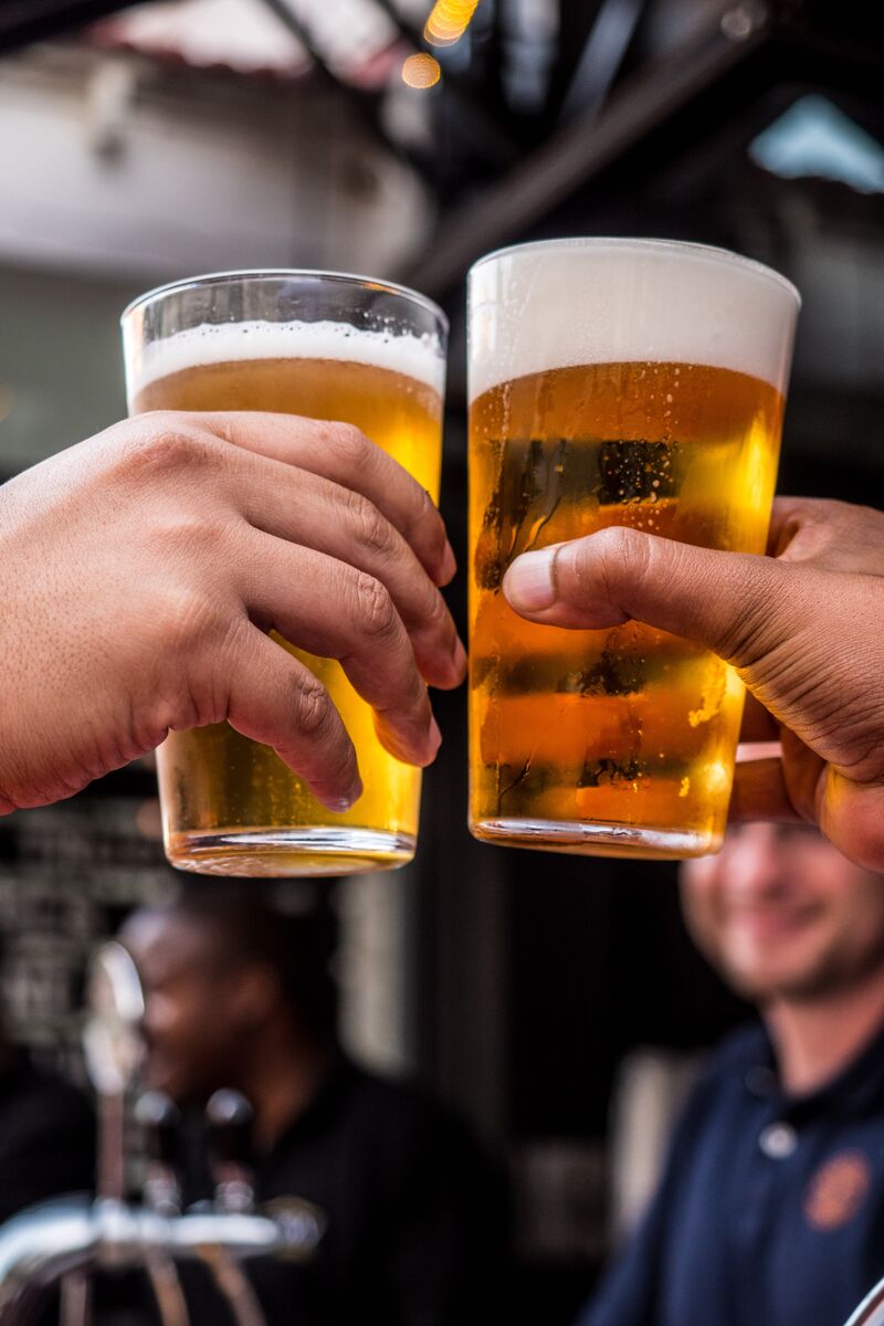 two people toasting with beer